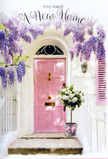You can almost hear the soft click of a gate and the hush of a quiet Pinner street in this gentle doorway scene, where flowers and colour come together to celebrate a move into a new home. The focus is a pretty pale pink front door, its surface smooth, recently painted, and catching the light with a subtle, welcoming sheen. Framing it from above and along the sides, lush wisteria cascades in long, dangling clusters of lavender and soft violet blooms. Each cluster hangs like a little bouquet, lending the entrance a dreamy, romantic feel and suggesting the sweet, powdery fragrance that often accompanies wisteria in late spring. The surrounding wall is whitewashed and slightly textured, giving depth to the scene, while a nearby shutter painted in a complementary pastel tone picks up the soft blush of the door and ties the composition together. On the doorstep rests a metal bucket filled to overflowing with white and cream roses, their generous, layered petals perfectly formed and full of quiet luxury. Nestled among them are delicate sprigs of green foliage, which add natural movement and a fresh garden accent. A slim pink ribbon, tied into an elegant bow around the base of the bucket, mirrors the door colour and adds a final, affectionate detail, as though the florist wanted to leave a small touch of joy behind. It feels like a housewarming gift just delivered to an address in HA5, waiting to be discovered. The overall atmosphere is serene and optimistic: wisteria framing the scene, roses glowing softly at the threshold, and every pastel tone working together to express a heartfelt message of welcome home in a new corner of Pinner.